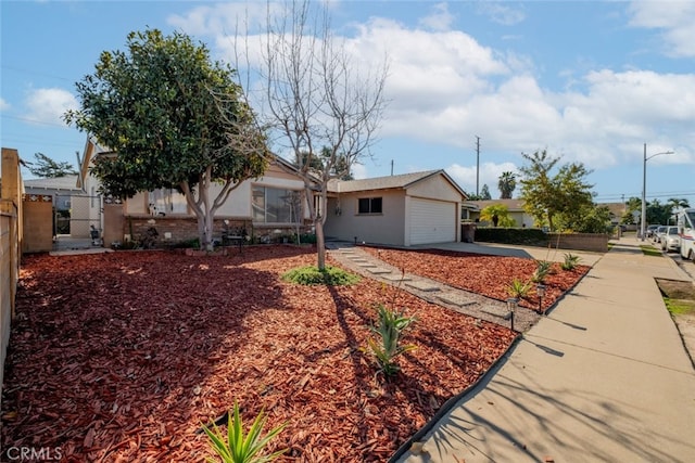 view of front of house with a garage, fence, and stucco siding