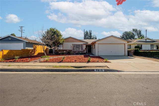 single story home with driveway, an attached garage, and fence