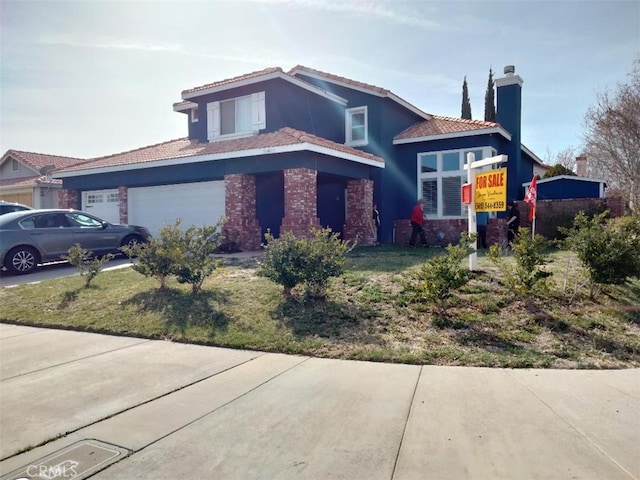 view of front of home with a chimney and an attached garage