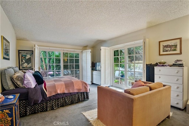 bedroom with access to exterior, light colored carpet, a textured ceiling, and multiple windows