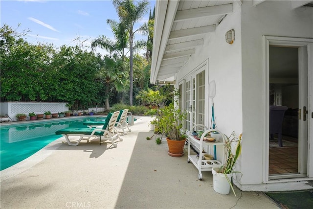 view of swimming pool featuring french doors, a patio area, fence, and a fenced in pool