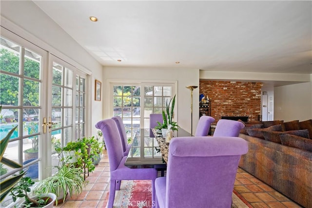 dining space featuring french doors, a fireplace, light tile patterned flooring, and recessed lighting