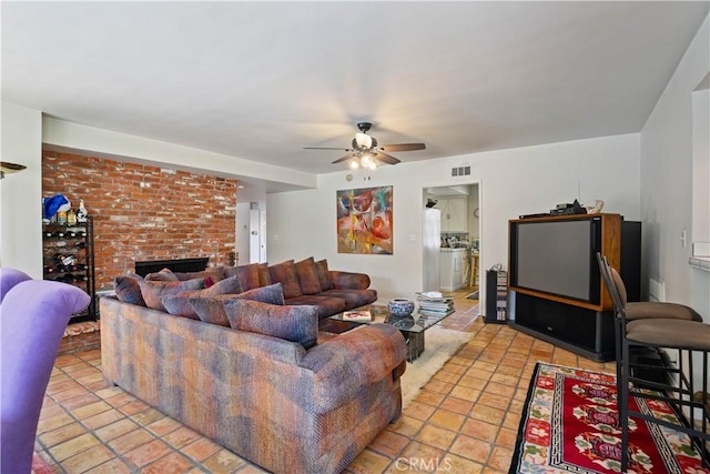 living room featuring a fireplace, visible vents, and a ceiling fan