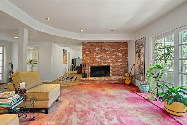 carpeted living area featuring recessed lighting, a fireplace, and baseboards