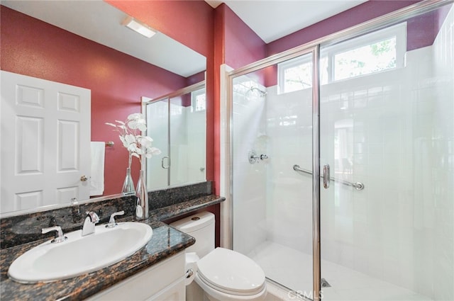 full bathroom with toilet, a shower stall, and vanity