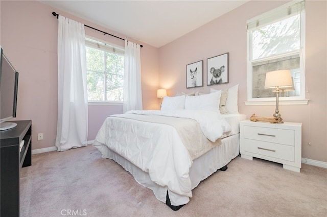 bedroom featuring light carpet and baseboards