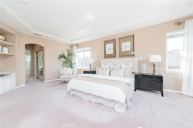 bedroom with arched walkways, baseboards, visible vents, and light colored carpet