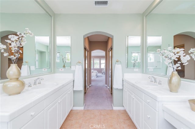 full bath with tile patterned flooring, visible vents, two vanities, and a sink