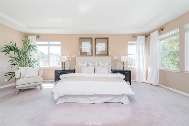 bedroom featuring light carpet, multiple windows, and baseboards