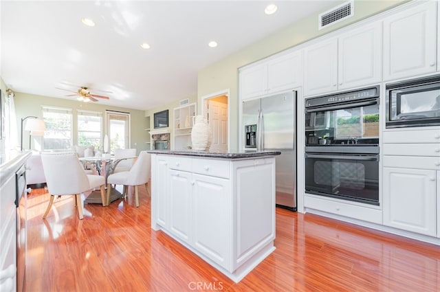 kitchen featuring visible vents, appliances with stainless steel finishes, light wood-style flooring, and white cabinetry