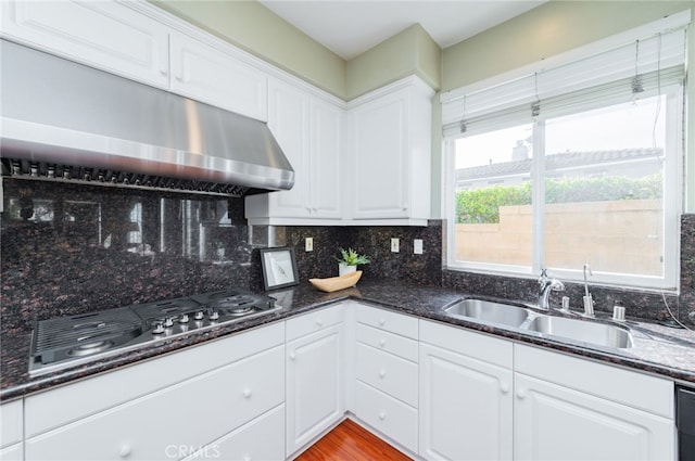 kitchen with stainless steel gas cooktop, a sink, and white cabinetry