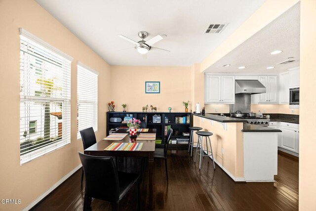 dining room with a ceiling fan, baseboards, visible vents, and dark wood-style flooring