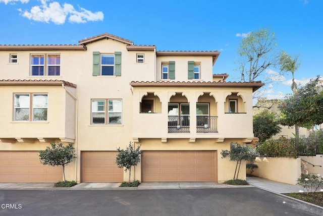 mediterranean / spanish-style home featuring an attached garage and stucco siding