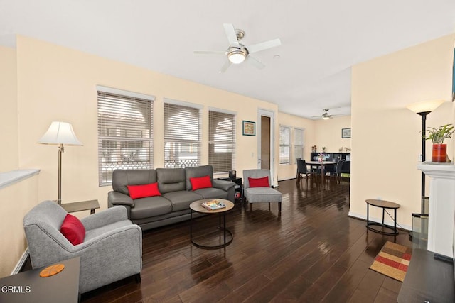 living area featuring ceiling fan, baseboards, and dark wood-type flooring