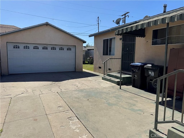 exterior space with a detached garage, an outbuilding, and stucco siding