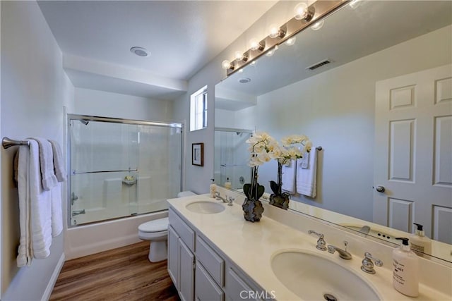 bathroom featuring visible vents, wood finished floors, a sink, and toilet