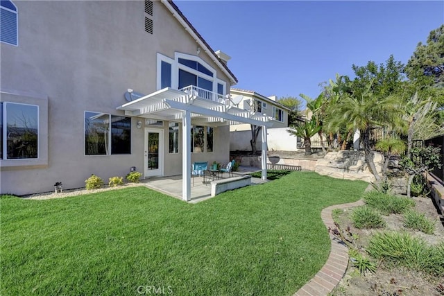 back of house featuring a patio, a pergola, a lawn, and stucco siding