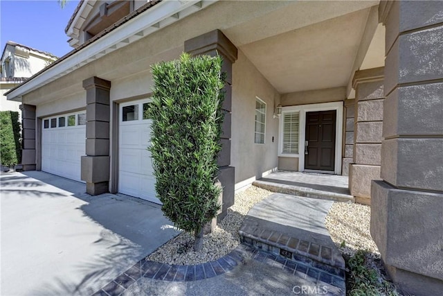 entrance to property with driveway and stucco siding