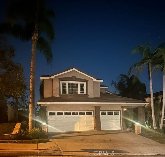 traditional-style house featuring an attached garage and concrete driveway