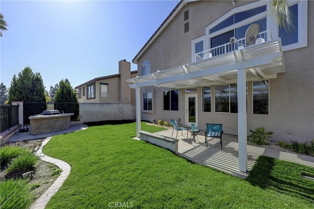 view of yard with a balcony, fence, a pergola, and a patio