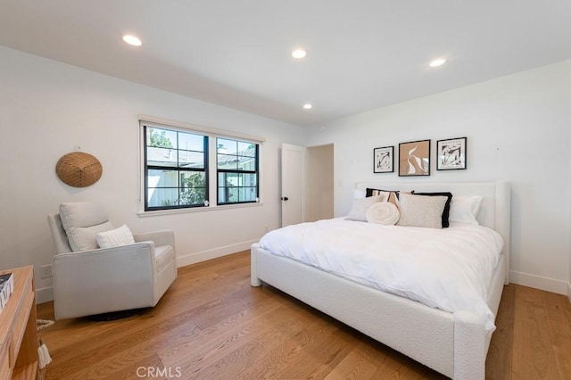 bedroom with recessed lighting, light wood-style flooring, and baseboards