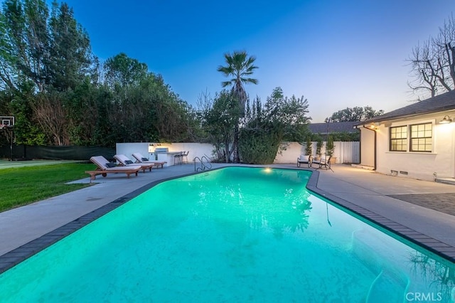 pool at dusk with a patio area, a fenced in pool, fence, and a lawn