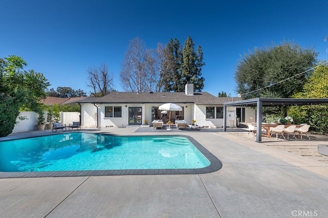 outdoor pool with a patio area, french doors, and fence