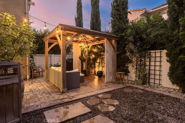 view of patio featuring a fenced backyard, an outdoor hangout area, and a gazebo