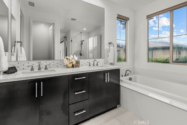 full bathroom with tile patterned flooring, visible vents, a sink, and a shower stall