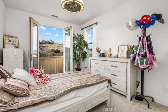 bedroom featuring visible vents, light carpet, and baseboards