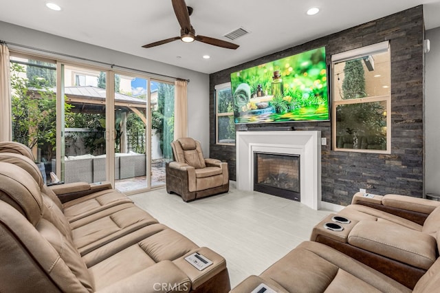 living area featuring a ceiling fan, a glass covered fireplace, visible vents, and recessed lighting