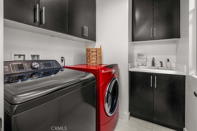 washroom with washer and clothes dryer, a sink, and cabinet space