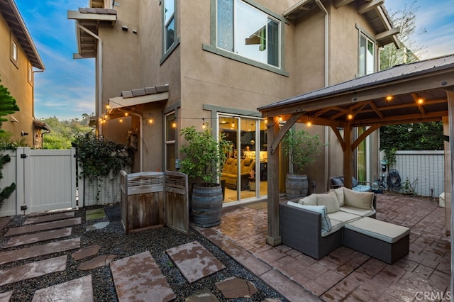 view of patio / terrace featuring a gazebo, outdoor lounge area, fence, and a gate