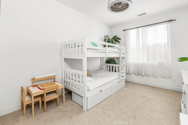 bedroom with light carpet, visible vents, and baseboards