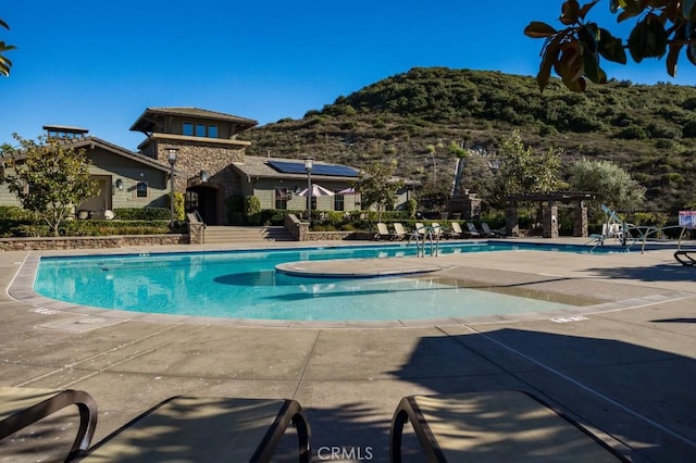 community pool featuring a mountain view and a pergola