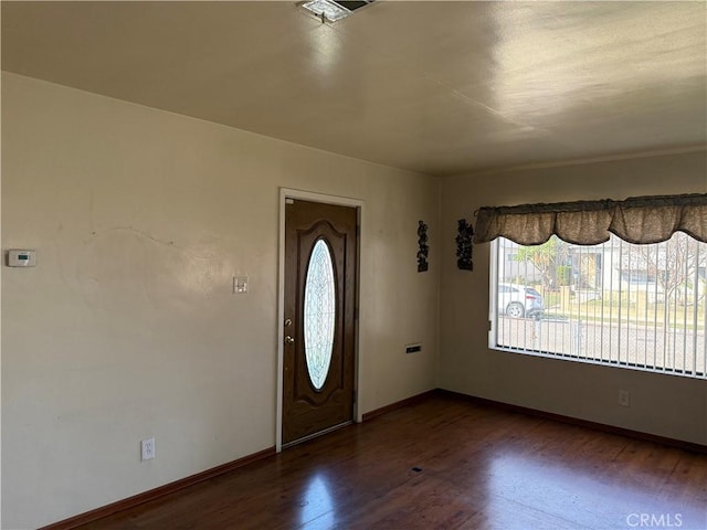 foyer featuring dark wood-style floors, visible vents, and baseboards