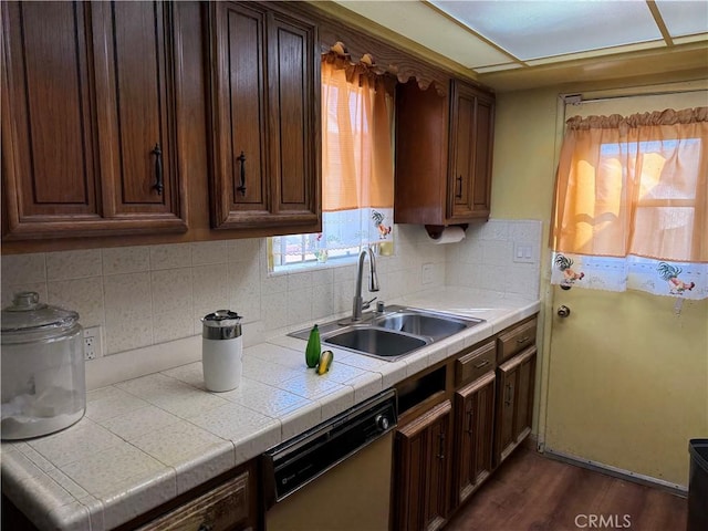 kitchen featuring tile counters, a sink, dishwashing machine, and dark brown cabinets