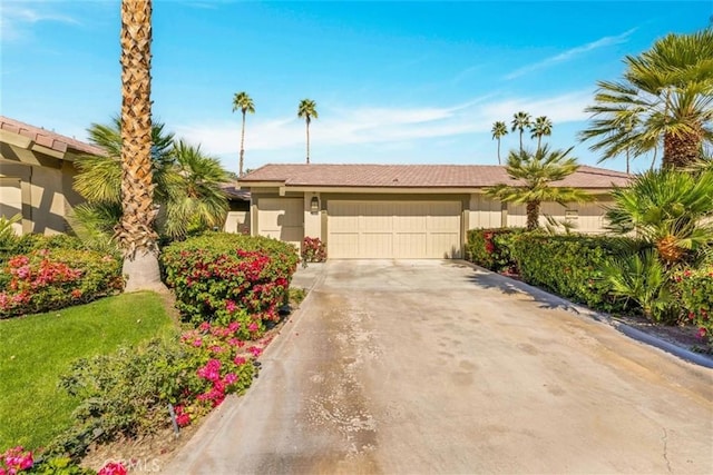 view of front of property with concrete driveway, an attached garage, and stucco siding