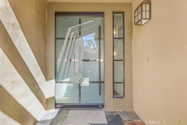 property entrance with stucco siding