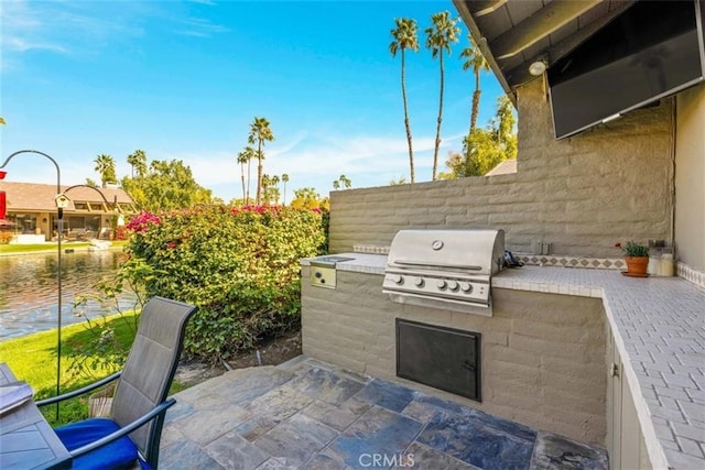 view of patio / terrace with a grill, fence, and exterior kitchen