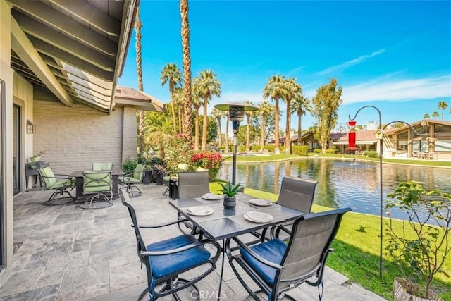 view of patio featuring a water view and outdoor dining area