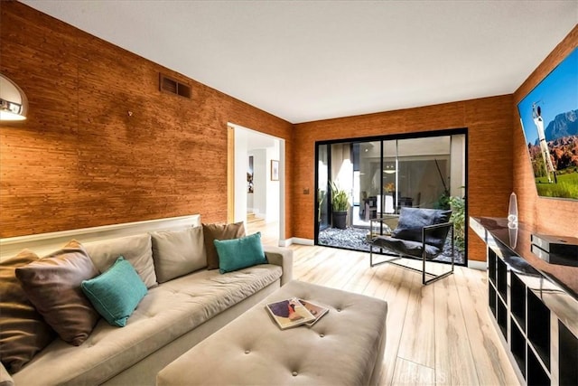 living area featuring light wood-style floors and visible vents