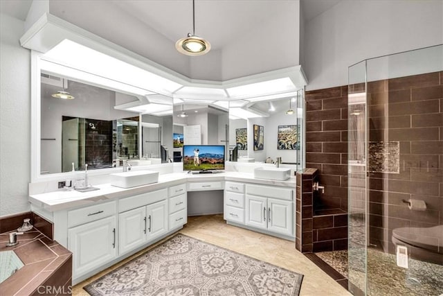 full bathroom featuring tiled shower, tile patterned flooring, and vanity