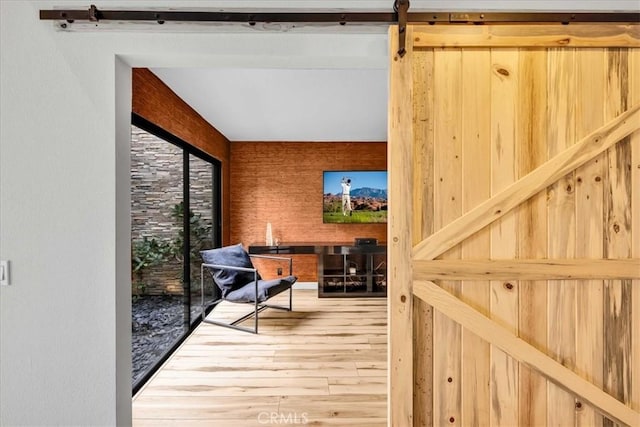 interior space with a barn door and wood finished floors