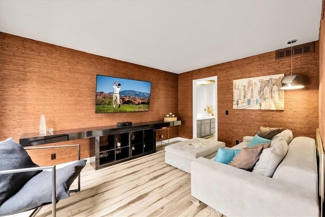 living area featuring visible vents and wood finished floors