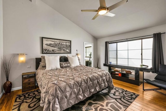 bedroom with ceiling fan, vaulted ceiling, baseboards, and wood finished floors