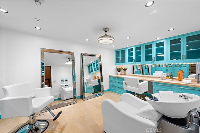 interior space with blue cabinets, glass insert cabinets, light countertops, and recessed lighting