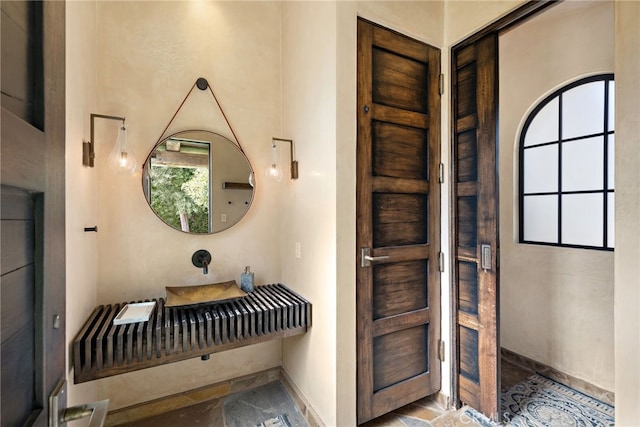 interior space featuring stone finish flooring, baseboards, and a wealth of natural light