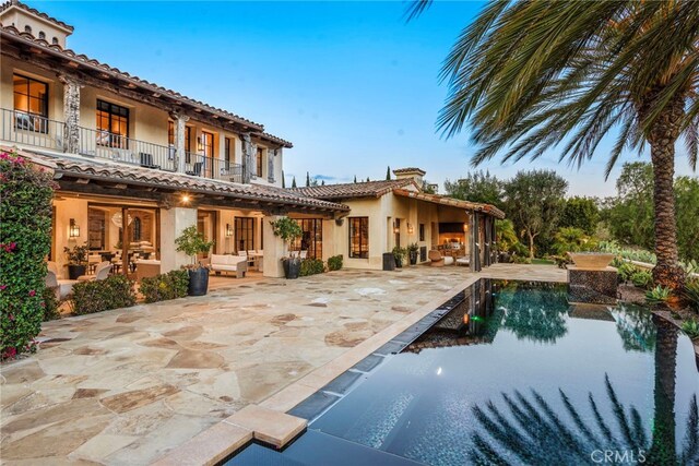 31 Blue Heron, Irvine, CA 92603 - back of property with stucco siding, a tiled roof, a balcony, outdoor lounge area, and a patio area