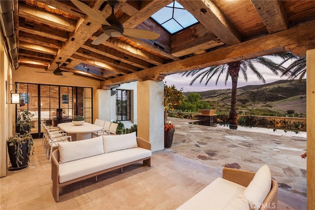 view of patio with a mountain view, an outdoor hangout area, and a ceiling fan